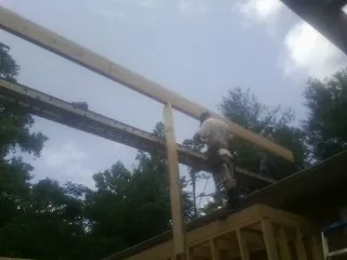 Carpenter setting a ridge beam over a new addition frame — Ice Dam Removal by Roofing Brothers in Herrin