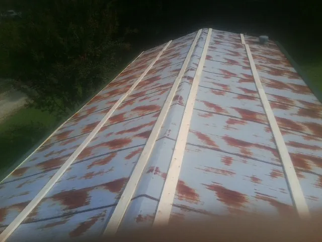 Rusted metal roof panels with new wood purlins before replacement — Storm Damage Roof Repair in Herrin by Roofing Brothers