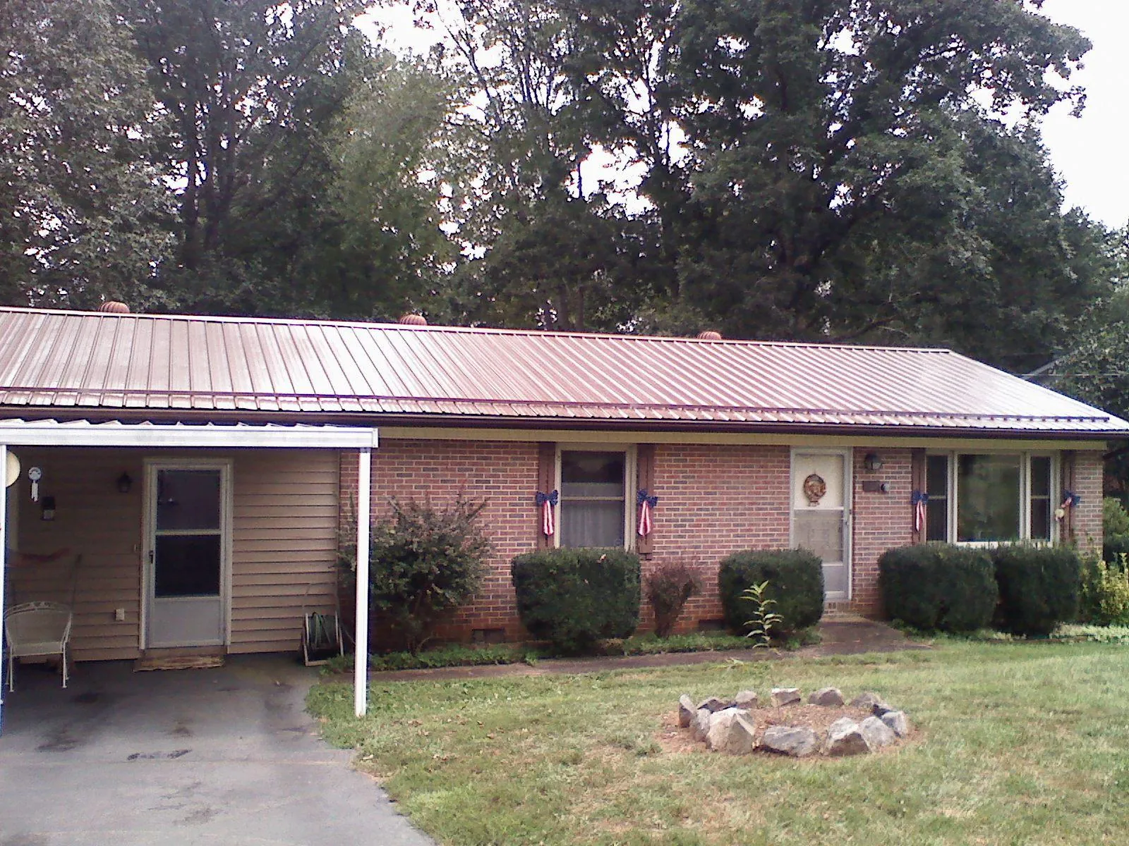 Bronze metal roof and carport on a brick ranch home — Roof Repair work by our crew in Herrin